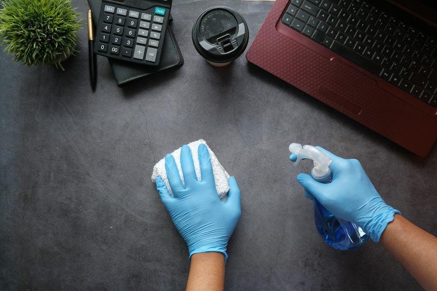 Cleaning technician in gloves disinfecting an office desk